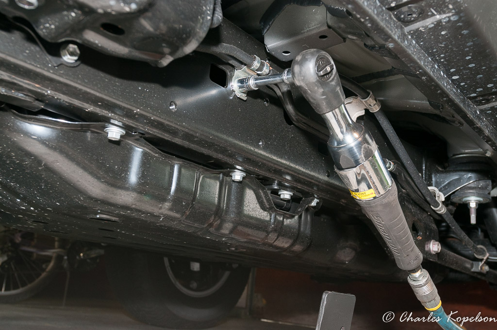 Remove the bolts holding the heard lines to the frame. You will need to slip the rock slider bracket under the lines.