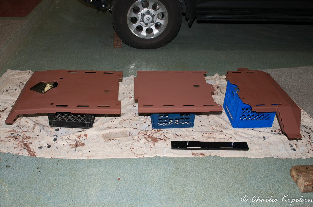 Left to right, Engine with oil filter cover, transmission and transfercase skid plates and T-case cross member spacer all primed. The hole at the rear of the engine cover is access to the oil drain bolt.