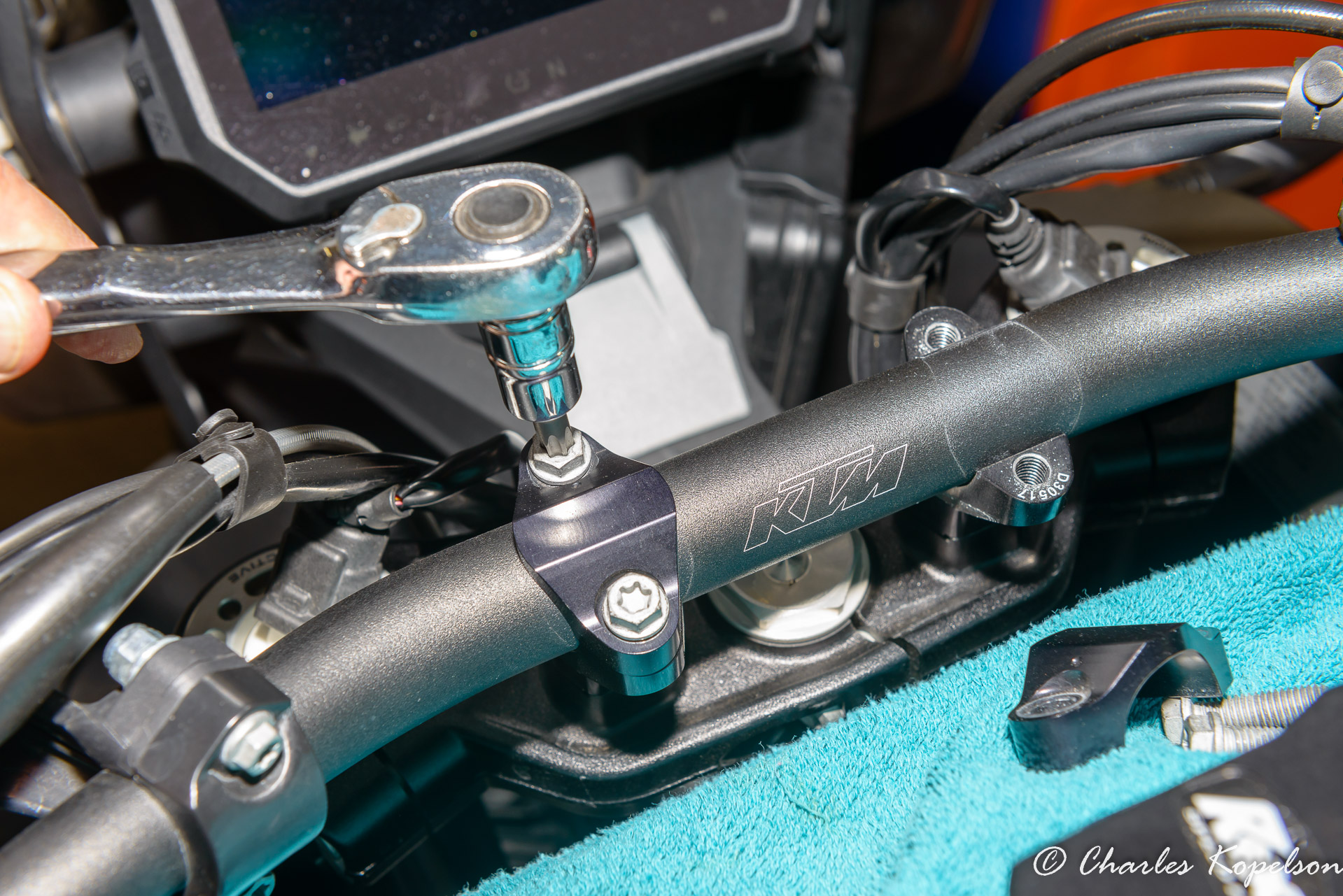 Put a towel on the tank so you don't scratch it. Remove the OEM handlebar clamps with a T40 Torx bit. For a bike with 4000 miles 2 of the screws were loose.