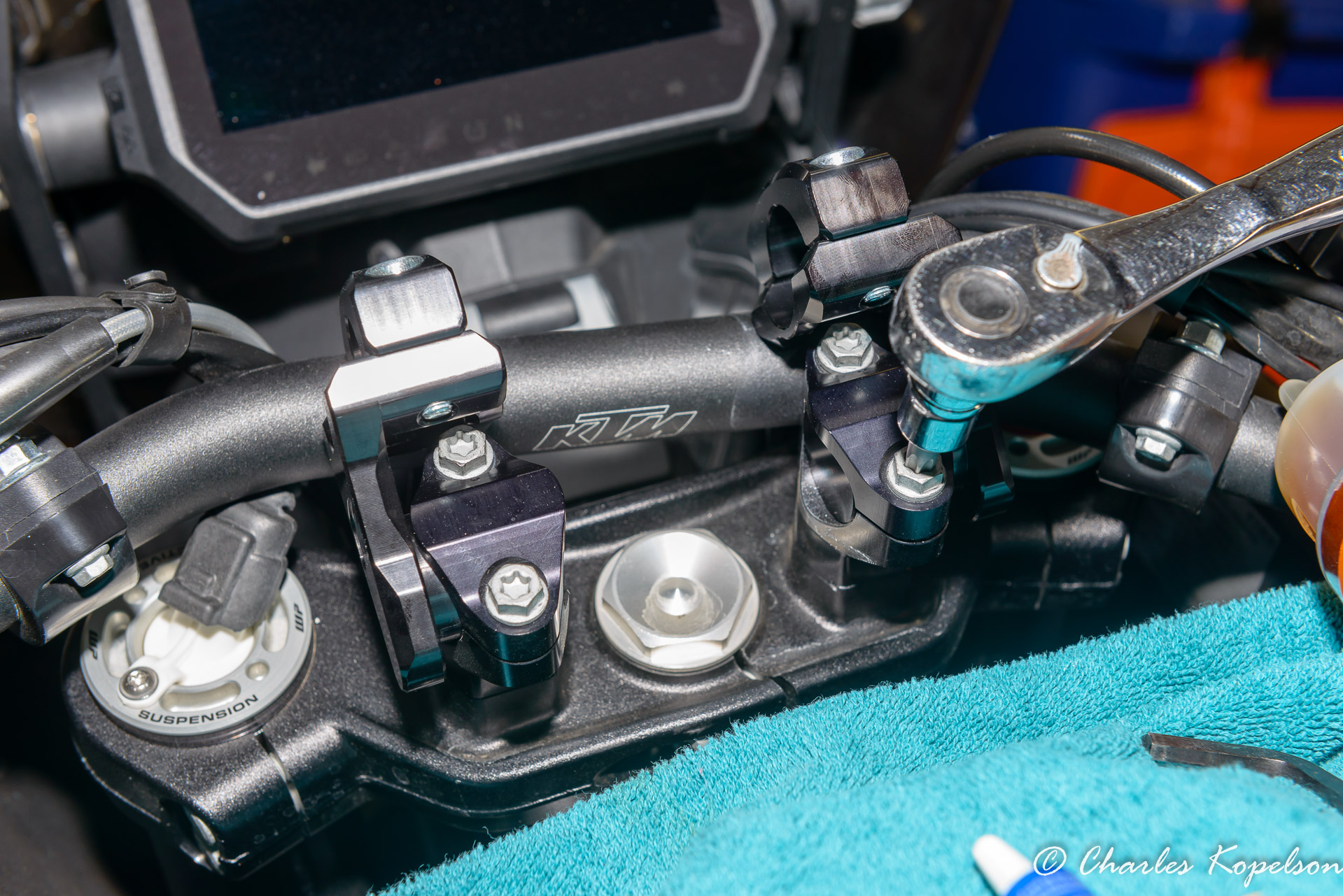 Put both handlebar clamps onto the risers on the bike and start the bolts. Insert the ROX risers into the clamps from the outside of the clamps.  Line them up so they're even.  Snug the bolts down so the new risers are hard to rotate.