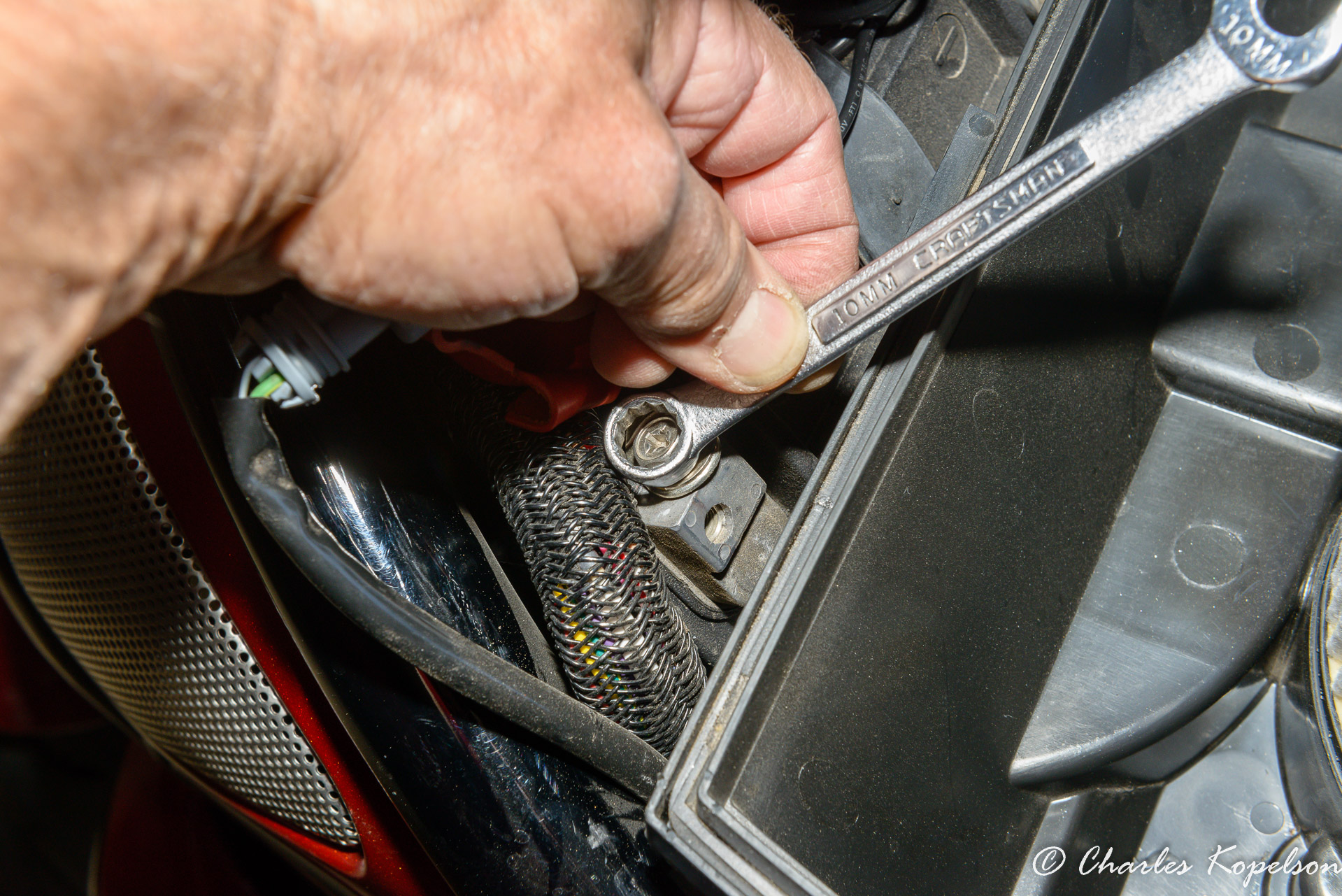 Using a 10mm wrench to loosen the battery screw. If you're doing the positive side make sure you don't touch the wrench to ground or you'll short the battery and get a spark.