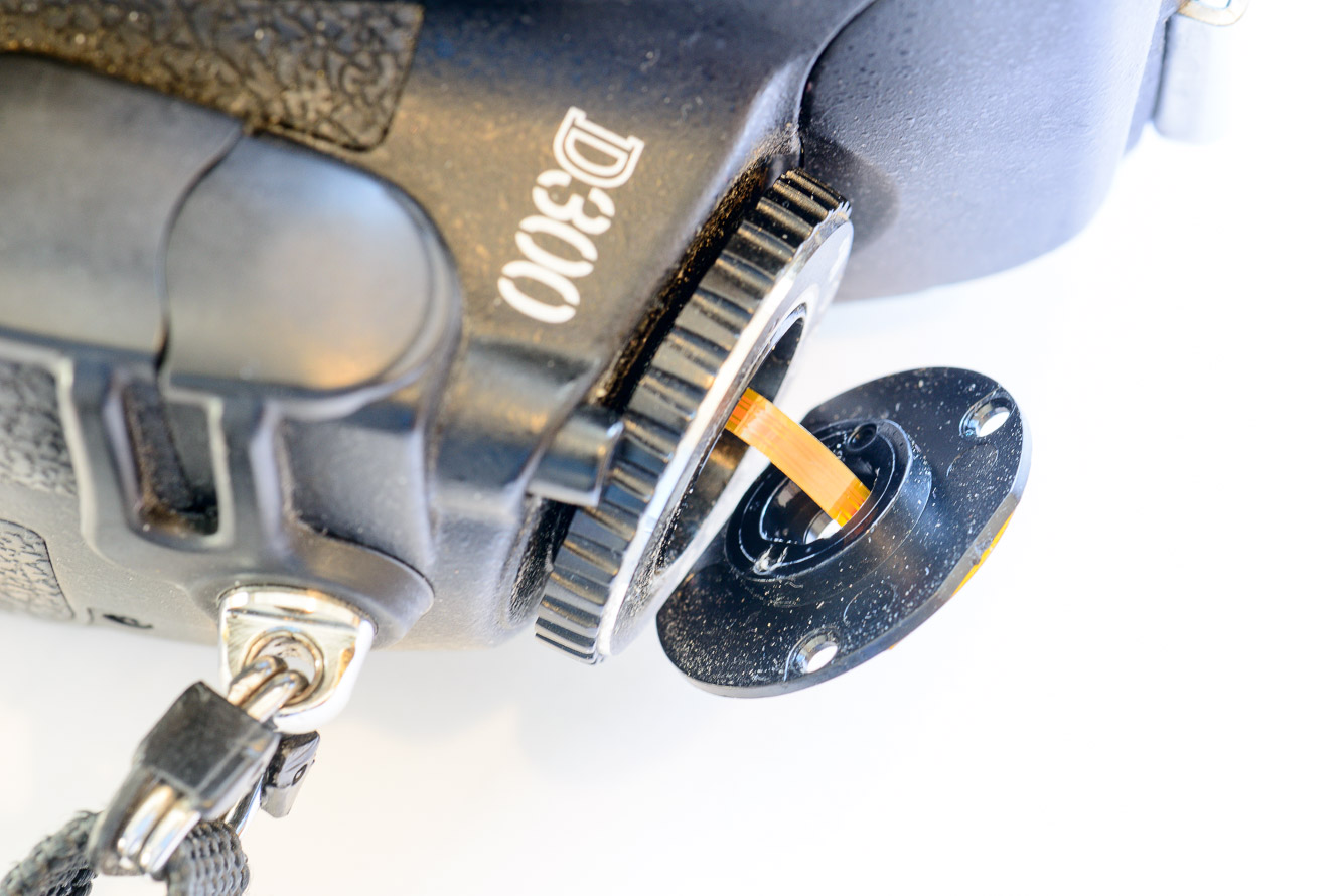 Carefully pull the button contact cluster board away from the camera so it's free enough to expose the 2 screw holes.  The ribbon cable will put out of the camera enough to do this.