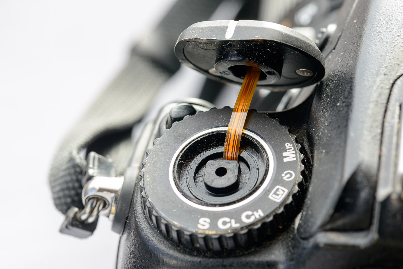 Carefully push the slack section of the ribbon cable down into the body.