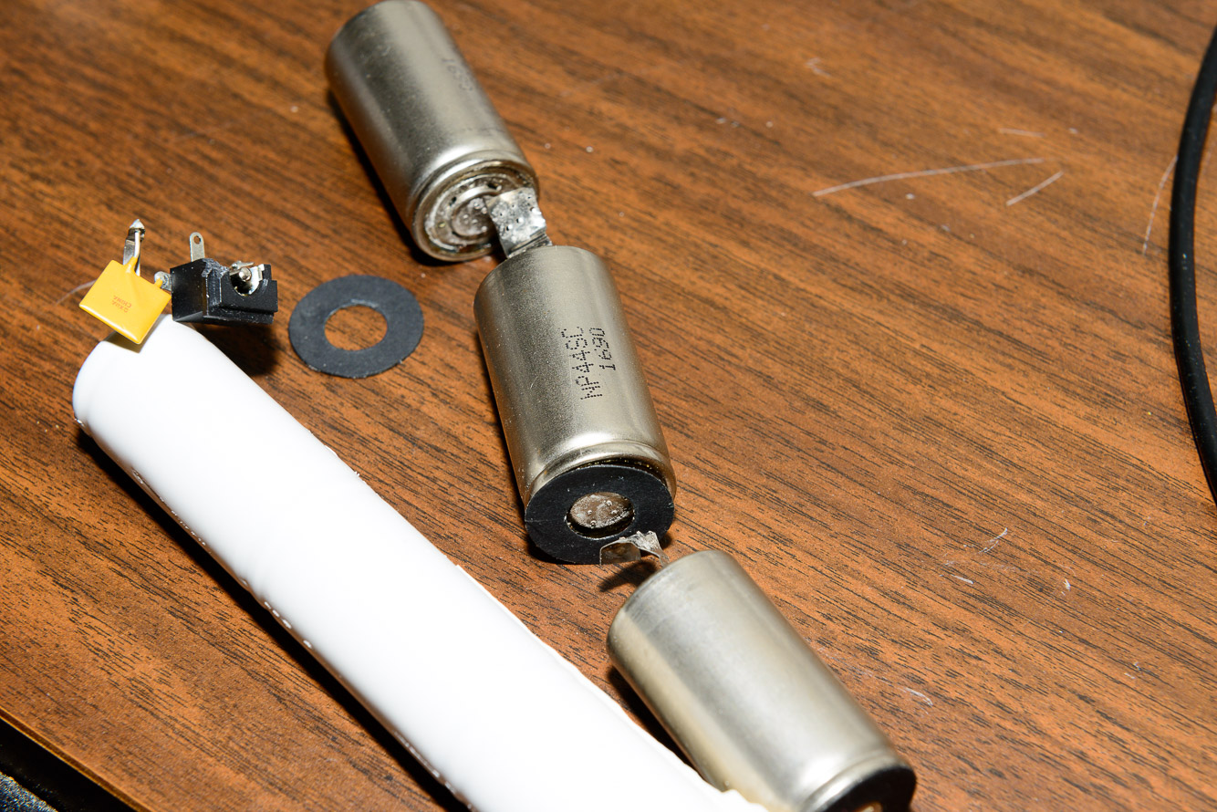 Take the old batteries apart.  I used a razor blade to slit the shrink wrap off.  Snip the tabs with a scissors and remove the black round insulators.